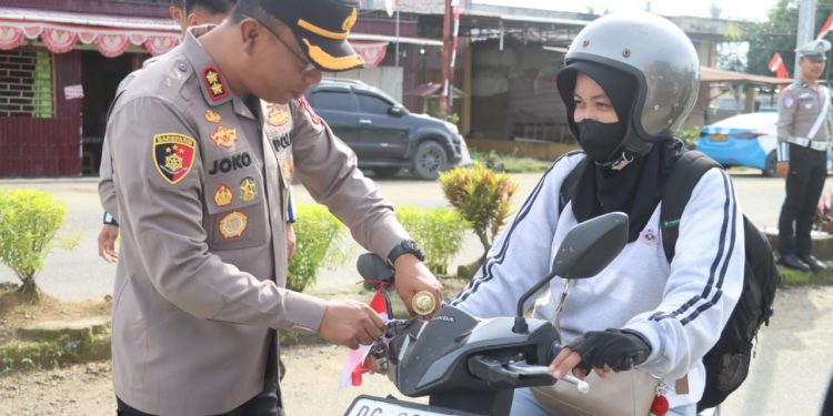 Polres Pasangkayu Bagikan Bendera Ke Pengendara